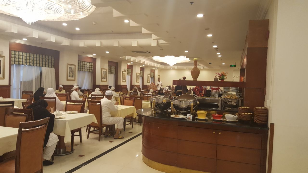 A group of pilgrims enjoying a meal together at their Haj accommodation